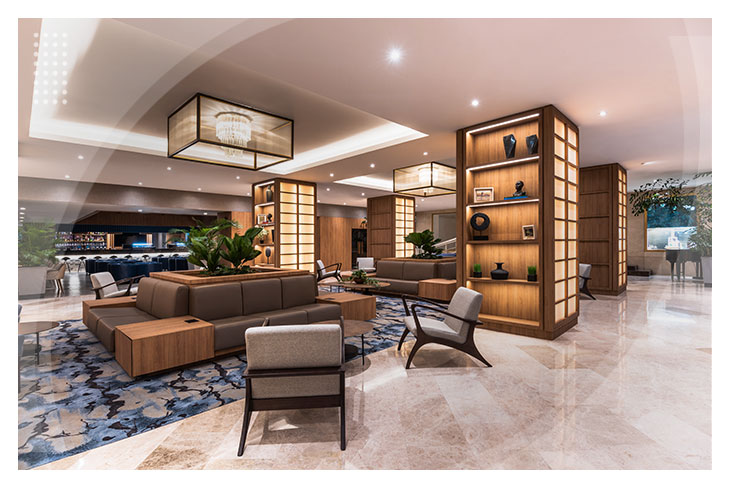 Sala de espera con sofás en tonos cálidos, estanterías decorativas y detalles de iluminación que reflejan la sofisticación del hotel Estelar Intercontinental