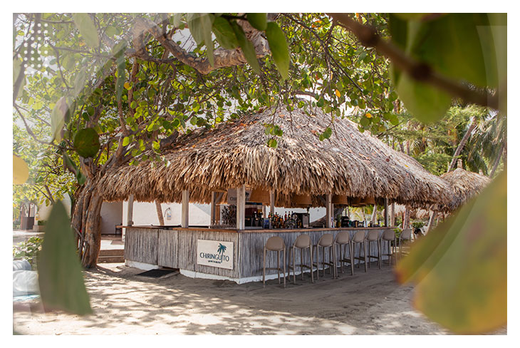 Bar rústico junto a la playa con sillas altas y ambiente natural perfecto para relajarse con las ofertas de hoteles en Santa Marta