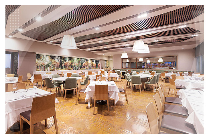 Amplio restaurante con decoración moderna, techos con textura, múltiples mesas y sillas que reflejan la comodidad y el buen gusto de una oferta especial en el Estelar Villavicencio