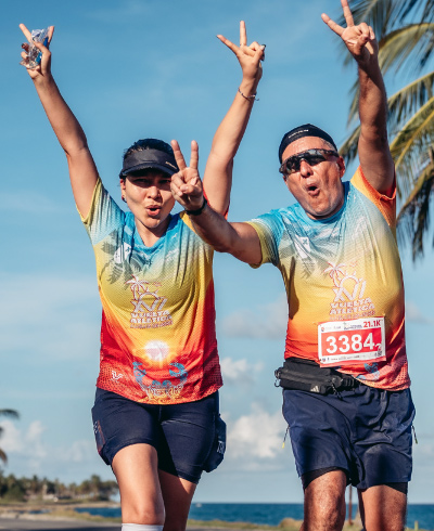 Pareja, vestida deportivamente con colores pasteles, está levantando las manos y celebrando que completó la vuelta a la isla de San Andrés