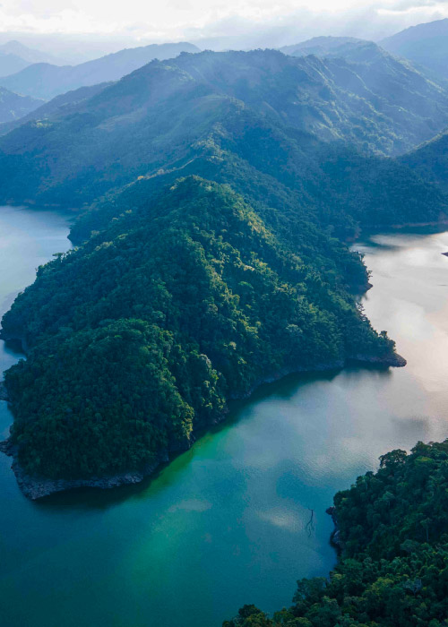 Toma aérea de una gran montaña, que está rodeada por el Río La miel en el departamento de Caldas, el que puedes conocer accediendo a uno de los paquetes turísticos de la agencia de viajes Compensar